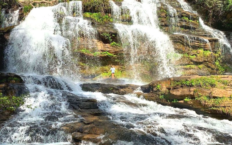 photo of girl under waterfall